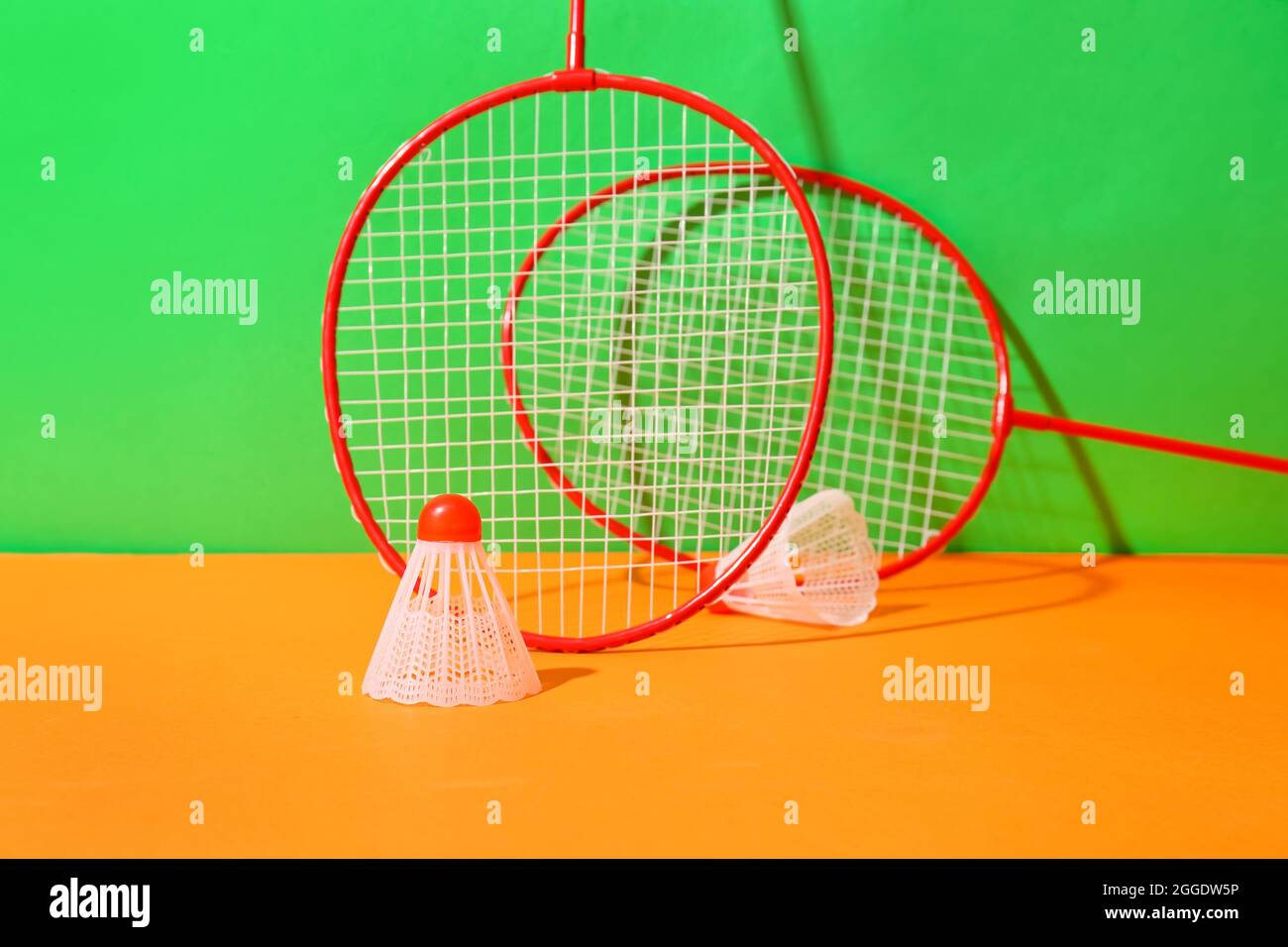 Badminton rackets and shuttlecocks on color background Stock Photo