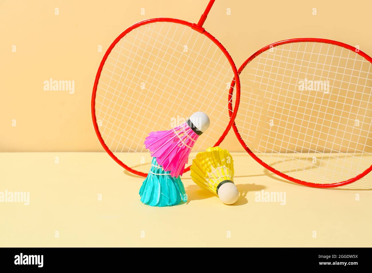 Badminton rackets and shuttlecocks on color background Stock Photo