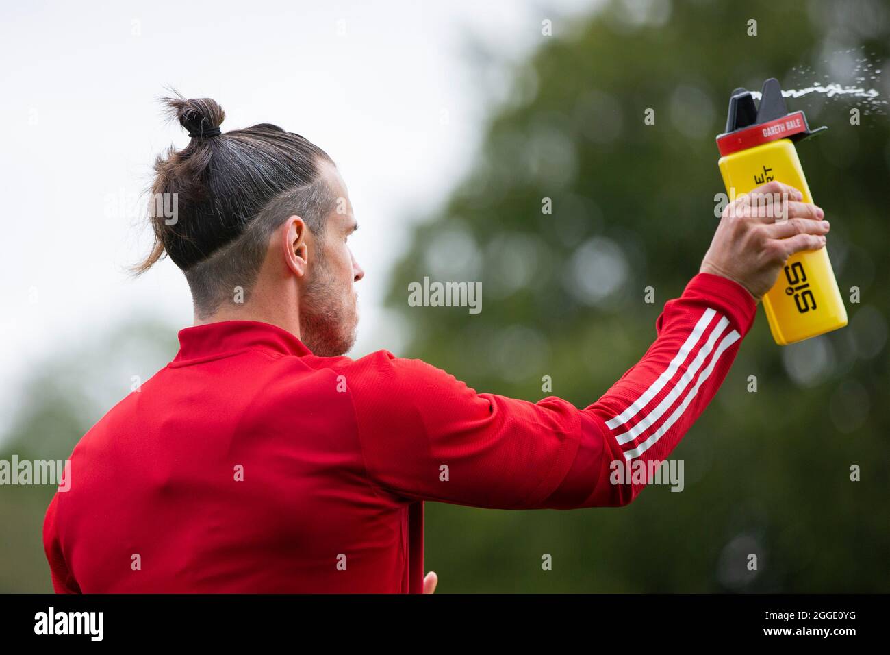 Hensol, Wales, UK. 31st Aug, 2021. Gareth Bale squirts water during Wales national football team training at Vale Resort ahead of the side's matches against Finland, Belarus and Estonia. Credit: Mark Hawkins/Alamy Live News Stock Photo