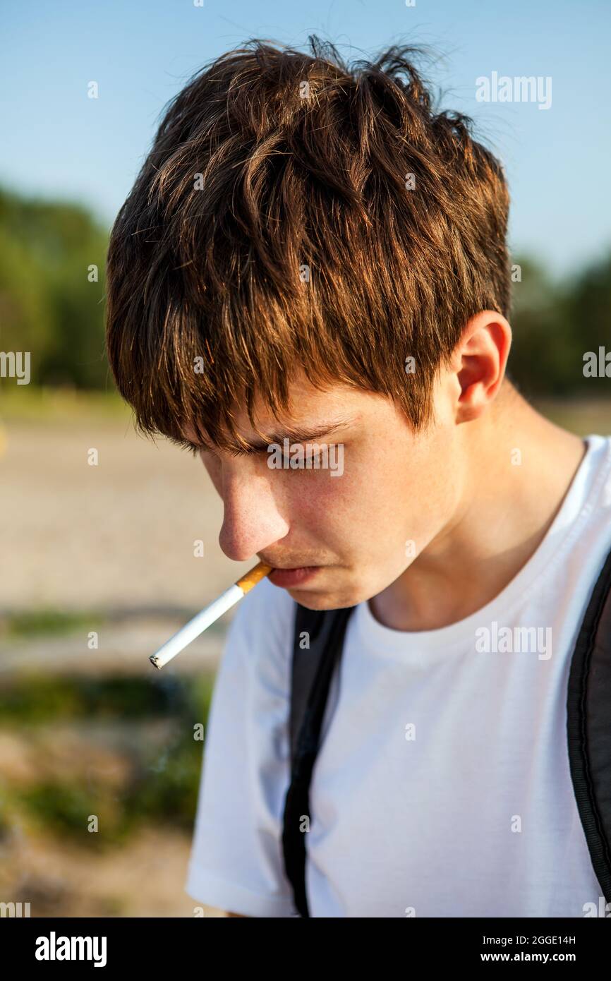 Sad Young Man smoking Cigarette on the Nature Background closeup Stock