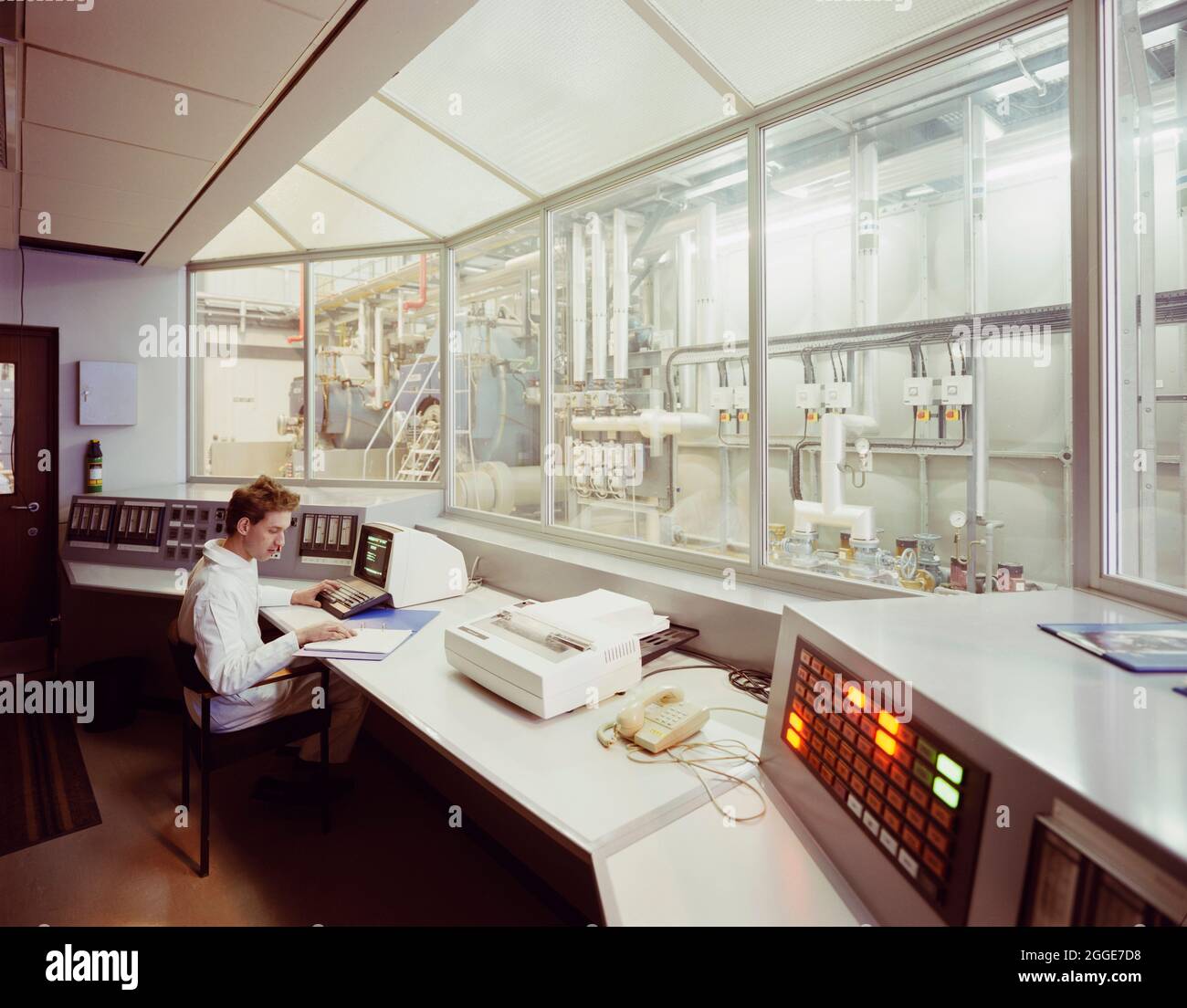 A worker entering data at a computer terminal in the control room of the boiler house at the Glaxo site in Ware. Laing built the new research building, gatehouse and services block at the Ware Glaxo site between 1985 and 1987, this &#xa3;7.5m contract was Phase IV of construction at the extensive site and multiple buildings were added in following years. Stock Photo