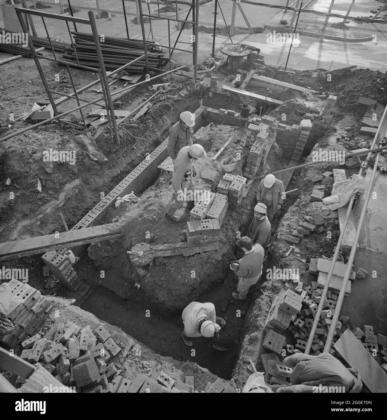 A team of bricklayers building walls in a foundation trench during construction works at the Glaxo site in Ware. Laing built the new research building, gatehouse and services block at the Ware Glaxo site between 1985 and 1987, this &#xa3;7.5m contract was Phase IV of construction at the extensive site and multiple buildings were added in following years. Stock Photo