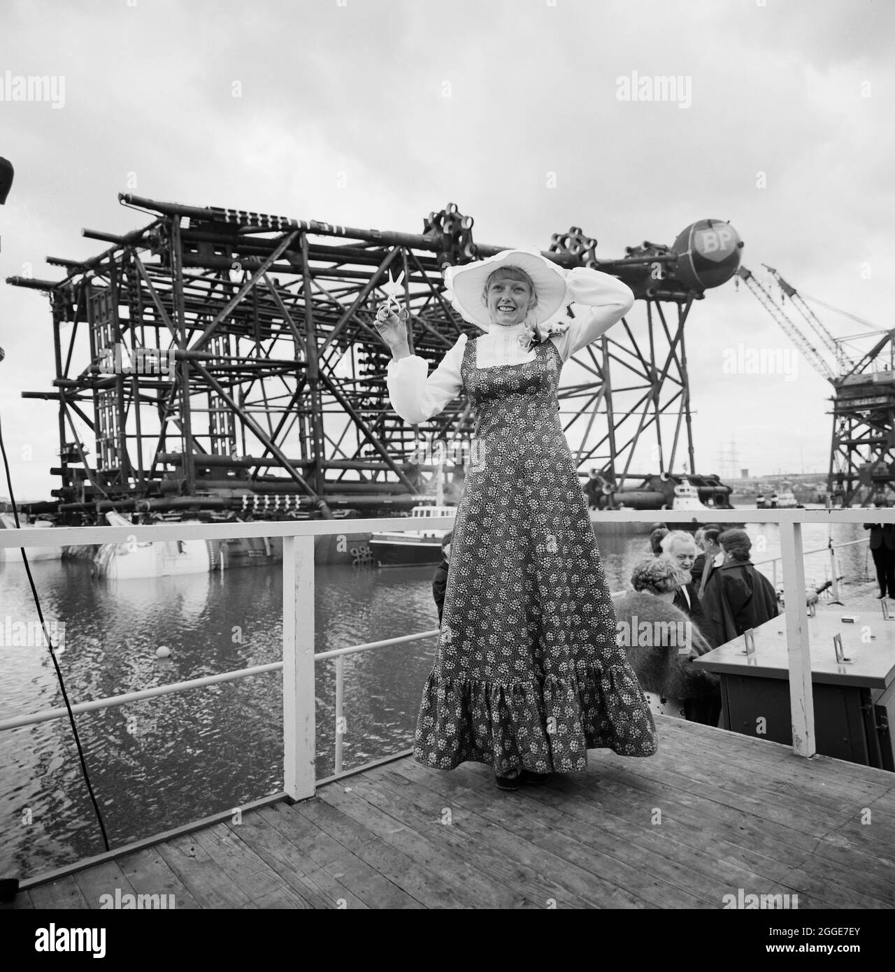 A young woman carrying out the naming ceremony for the oil platform Graythorp II. In the early 1970s Laing Pipelines Offshore constructed the Graythorp fabrication yard and dry dock on the site of the old William Gray Shipyard. The company created a dry dock which was used for the construction of fixed platform North Sea drilling rigs for the BP North Sea Oil Project. The oil platform Graythorp I was launched on Saturday 29th June 1974 and on the weekend of 14th-15th June 1975, Graythorp II was named and floated out of the dock basin down the Seaton Channel to where it was handed over to its o Stock Photo