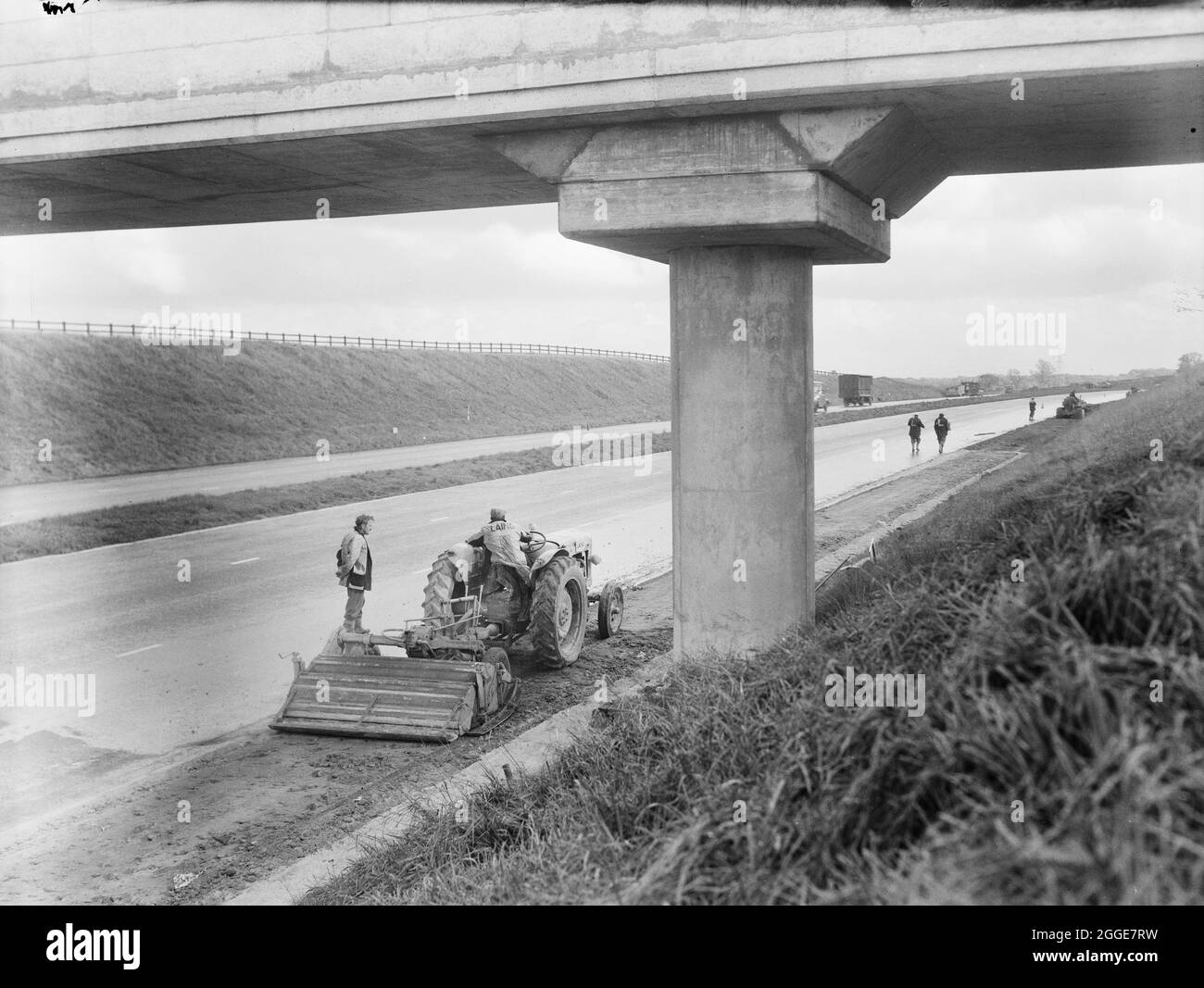 A view of hard shoulder reconstruction works on the M1, the London to Yorkshire Motorway, showing a multipass stabiliser machine at work beneath a bridge. The album caption refers to this image as the 'London/Birmingham Motorway'. Stock Photo
