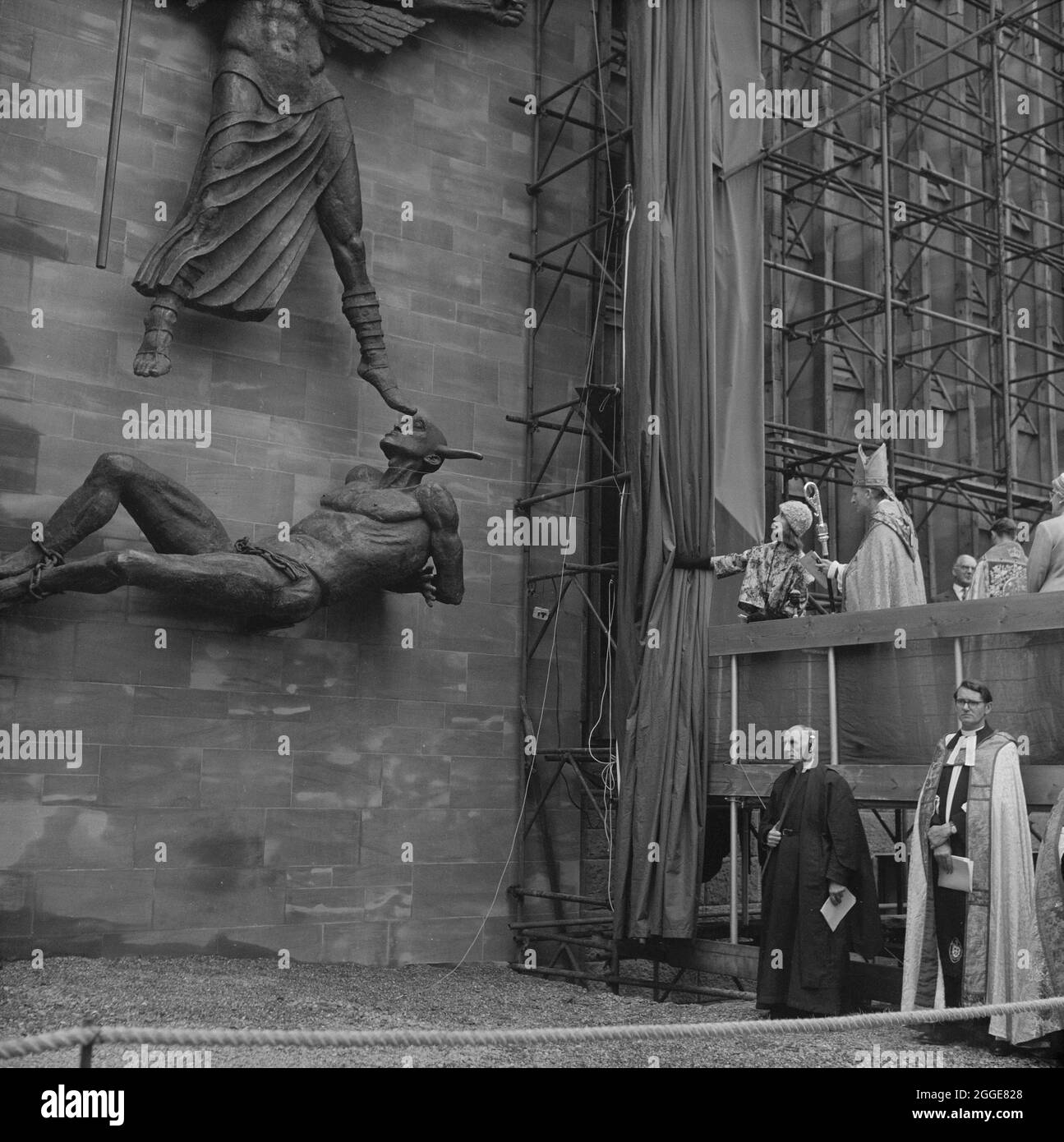 Lady Epstein unveiling the statue St Michael and the Devil by sculptor Jacob Epstein at Coventry Cathedral. The statue of the Archangel Michael overcoming the Devil was the last sculpture Sir Jacob Epstein created before he died in 1959. The statue overlooks the steps leading up to the entrance of Coventry Cathedral. Stock Photo