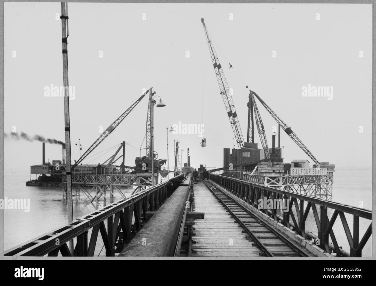 A view along the Bailey bridge towards the intake works on the Berkeley Nuclear Power Station construction site. This image was catalogued as part of the Breaking New Ground Project in partnership with the John Laing Charitable Trust in 2019-20. Stock Photo