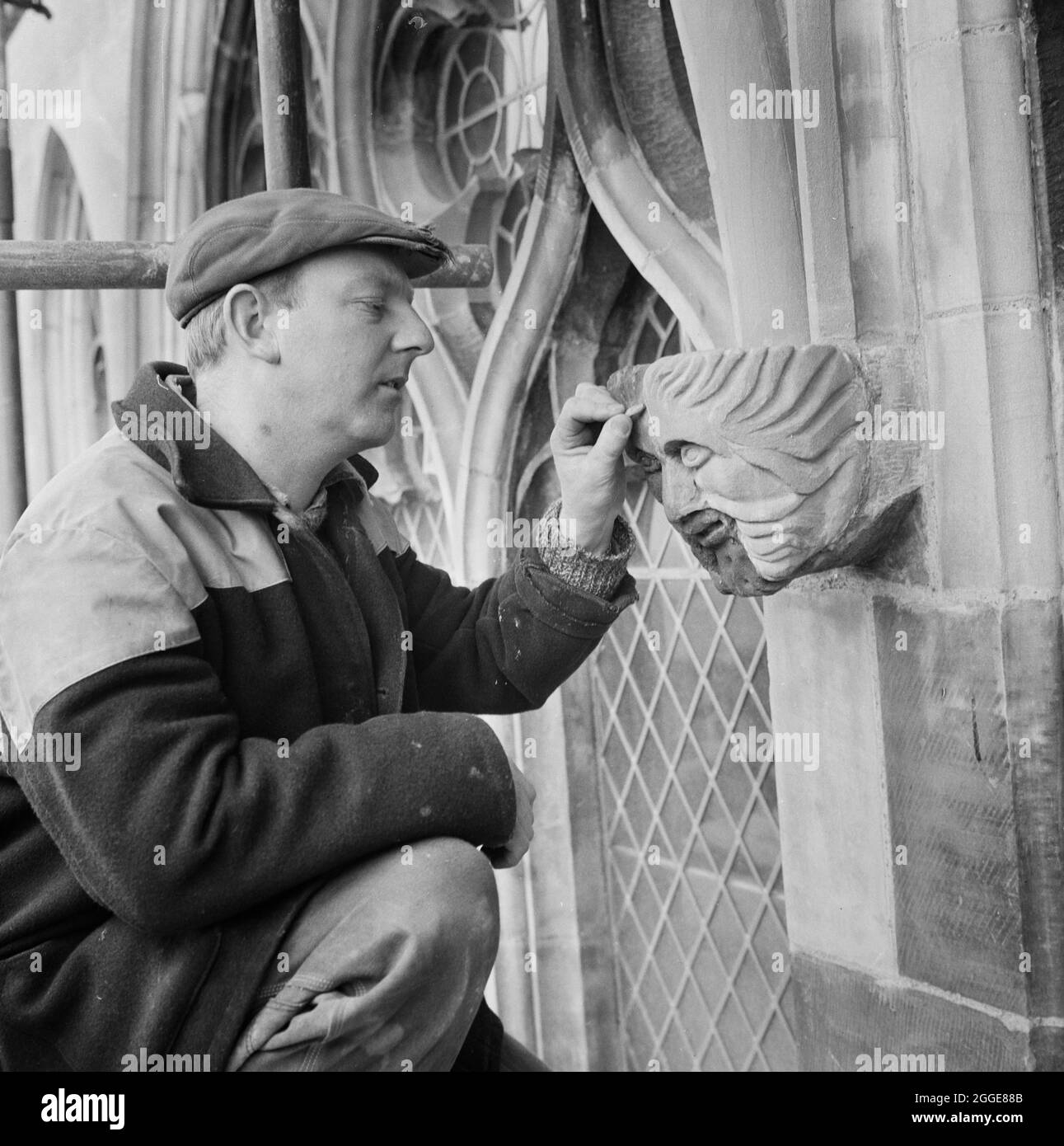 Foreman stonemason, Ted Drinkwater, working at Carlisle Cathedral checking  a stone head on the north face of the cathedral. Half its face had been  replaced using SBD Certite as the adhesive. This