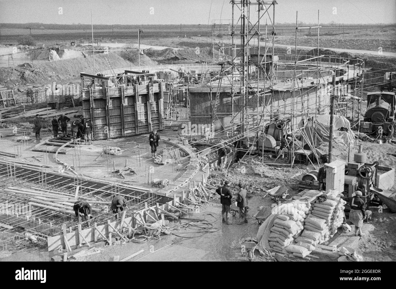 A view over the construction site for two sugar silos at Bardney Sugar Factory, showing Laing workers carrying out various tasks. Two sugar silos were built by Laing for the British Sugar Corporation Limited at the Bardney Sugar Factory. The prestressed post-tensioned concrete silos were made with sliding formwork using hydraulic climbing jacks. Stock Photo