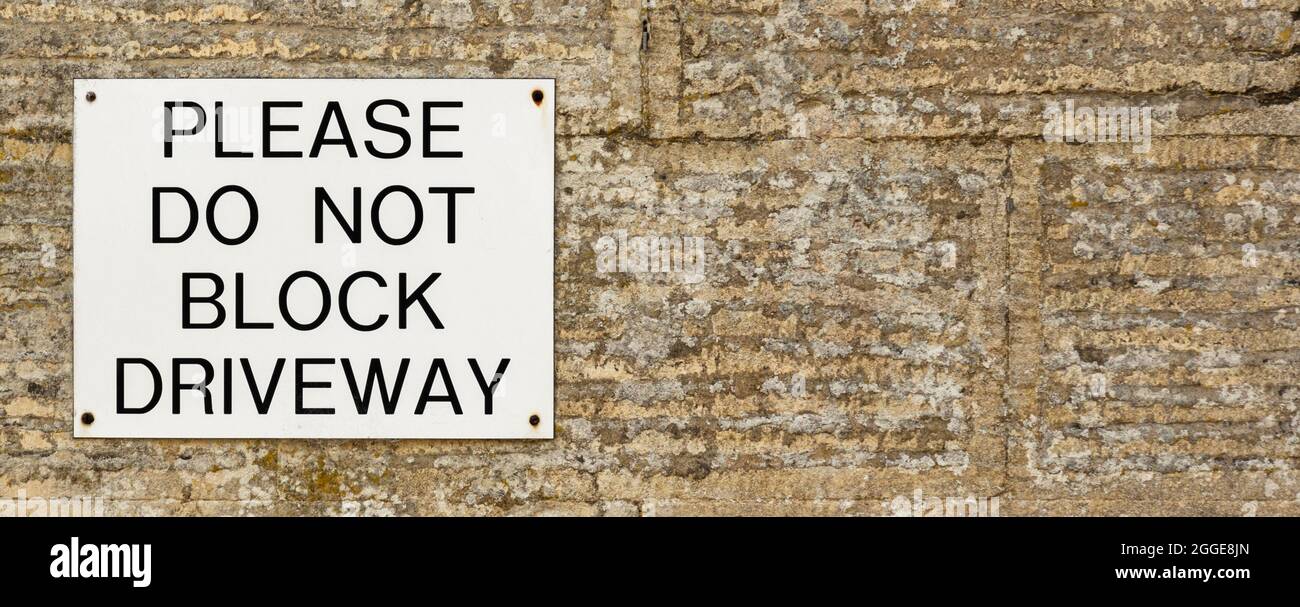 Do Not Block Driveway sign on stone wall, background banner image Stock Photo