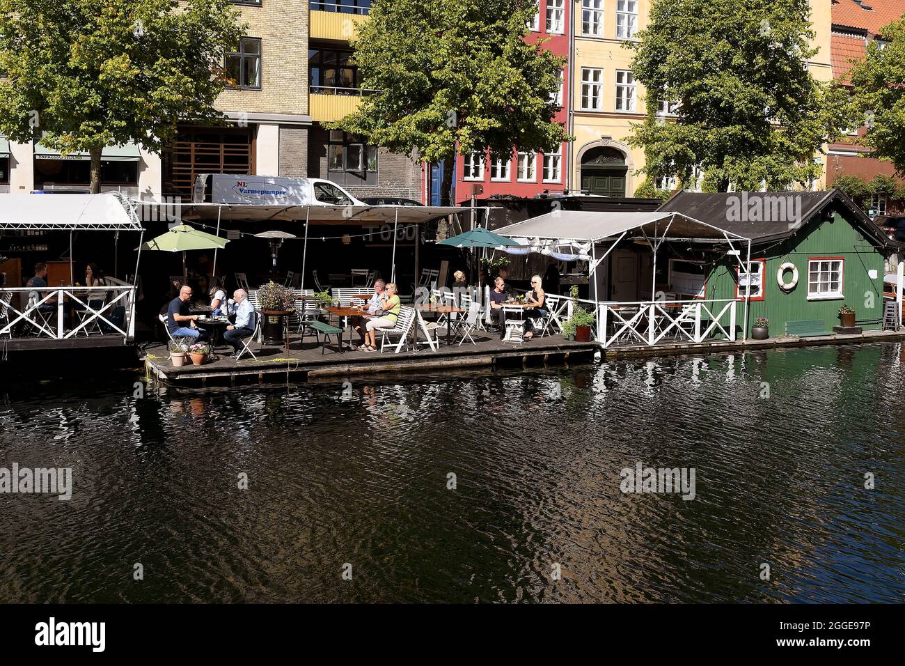 Copenhagen, Denmark., 31 August 2021,Cafe guest enjoy sun shine fall weather day on Canal cafe for out door food seervice  on Christianshavn canal in Stock Photo