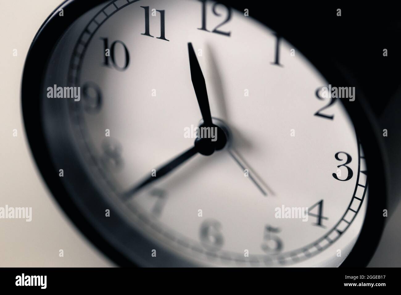 Soft focus on hour clockwise at half pass eleven o'clock before midnight of black and white classic clock. Stock Photo