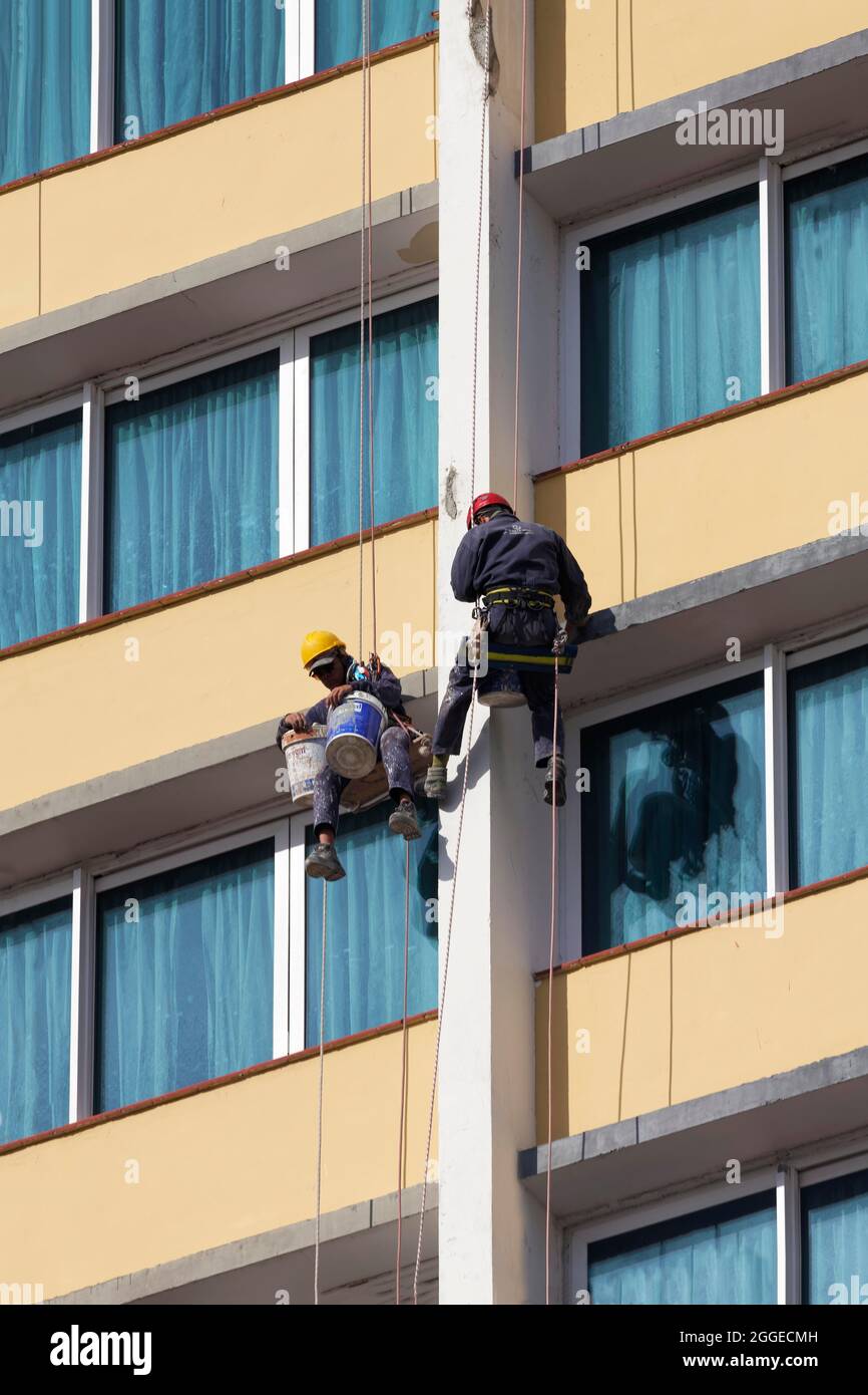 Two facade climbers hanging from a rope, Cubans, repairing damage to house facade, Old Town, Capital Havana, Havana Province, Greater Antilles Stock Photo