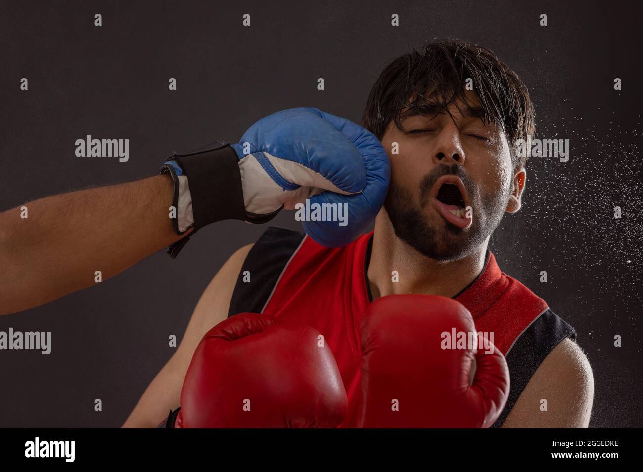A BOXER BEING PUNCHED BY ANOTHER PLAYER DURING A BOXING MATCH Stock
