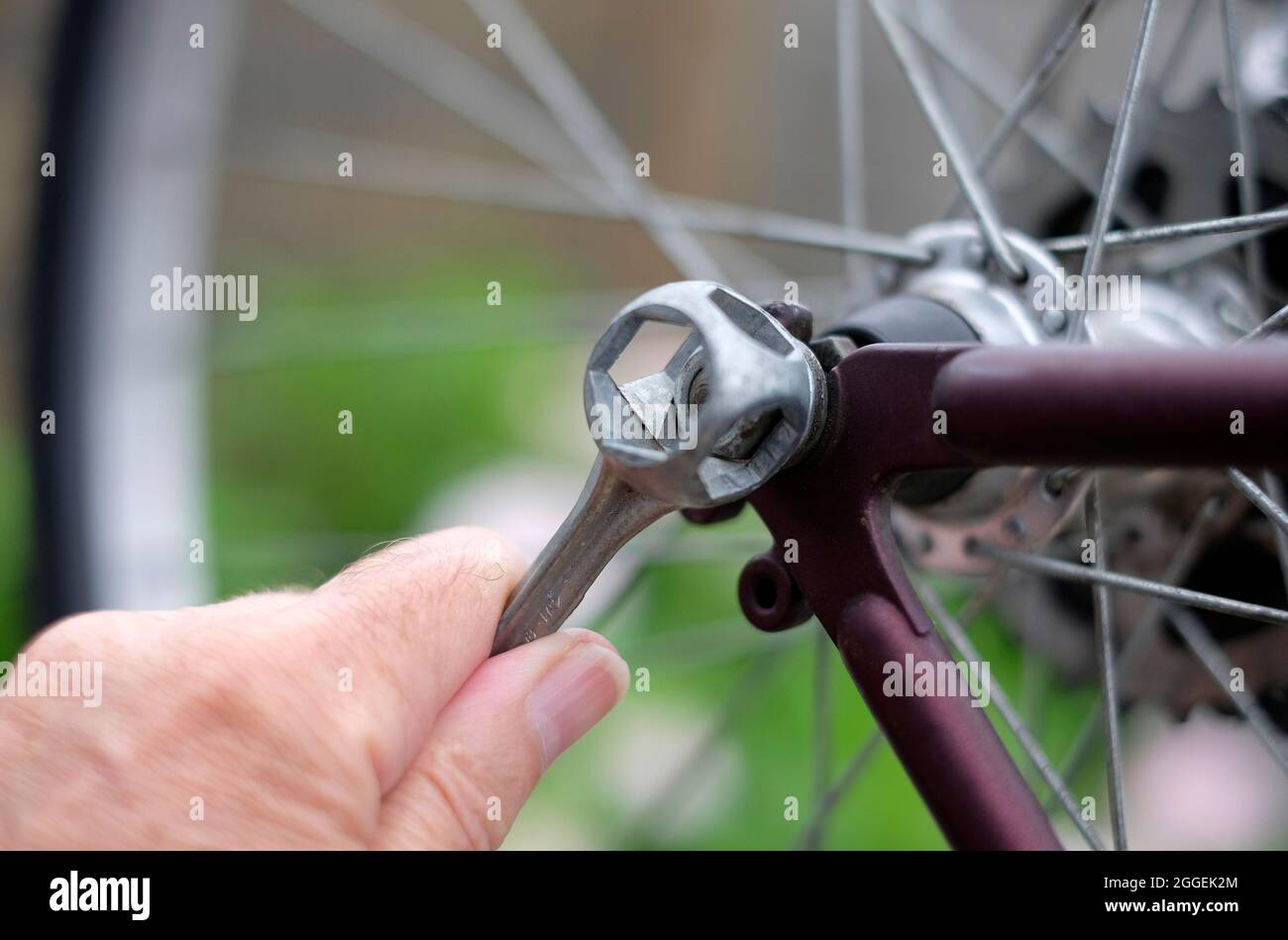 male person tightening wheel nut on mountain bike with spanner, norfolk, england Stock Photo