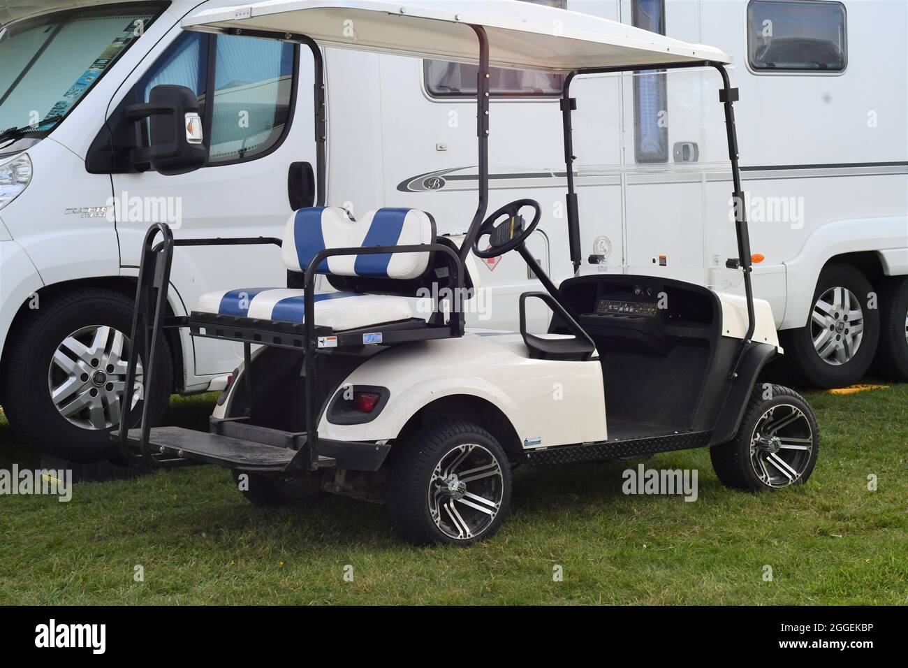 An electric buggy parked next to a motorhome Stock Photo