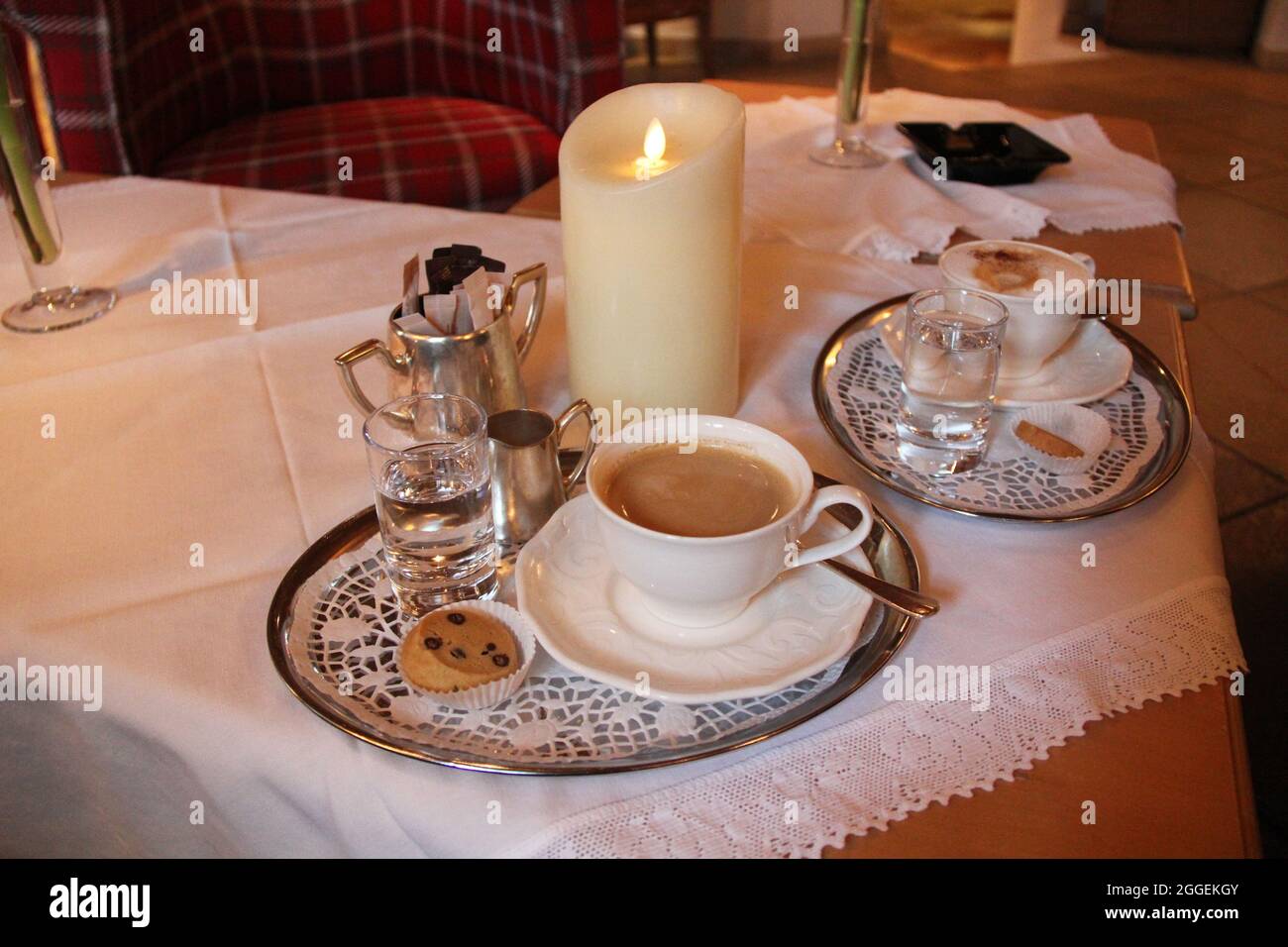 Coffee with Silver on Table with Candle Stock Photo