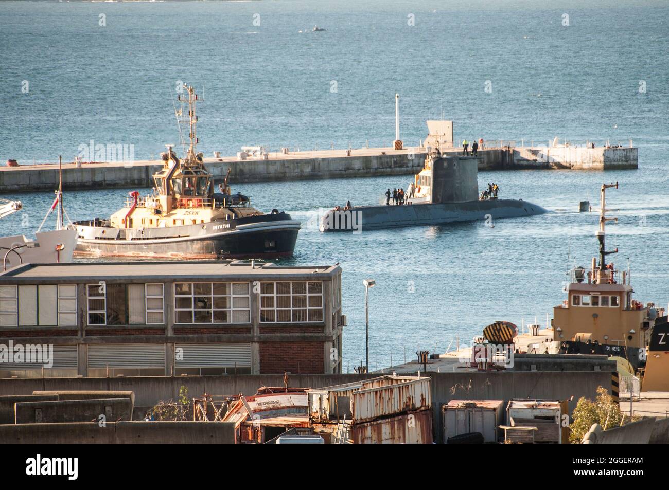SA Navy Submarine docking with tugboats Stock Photo