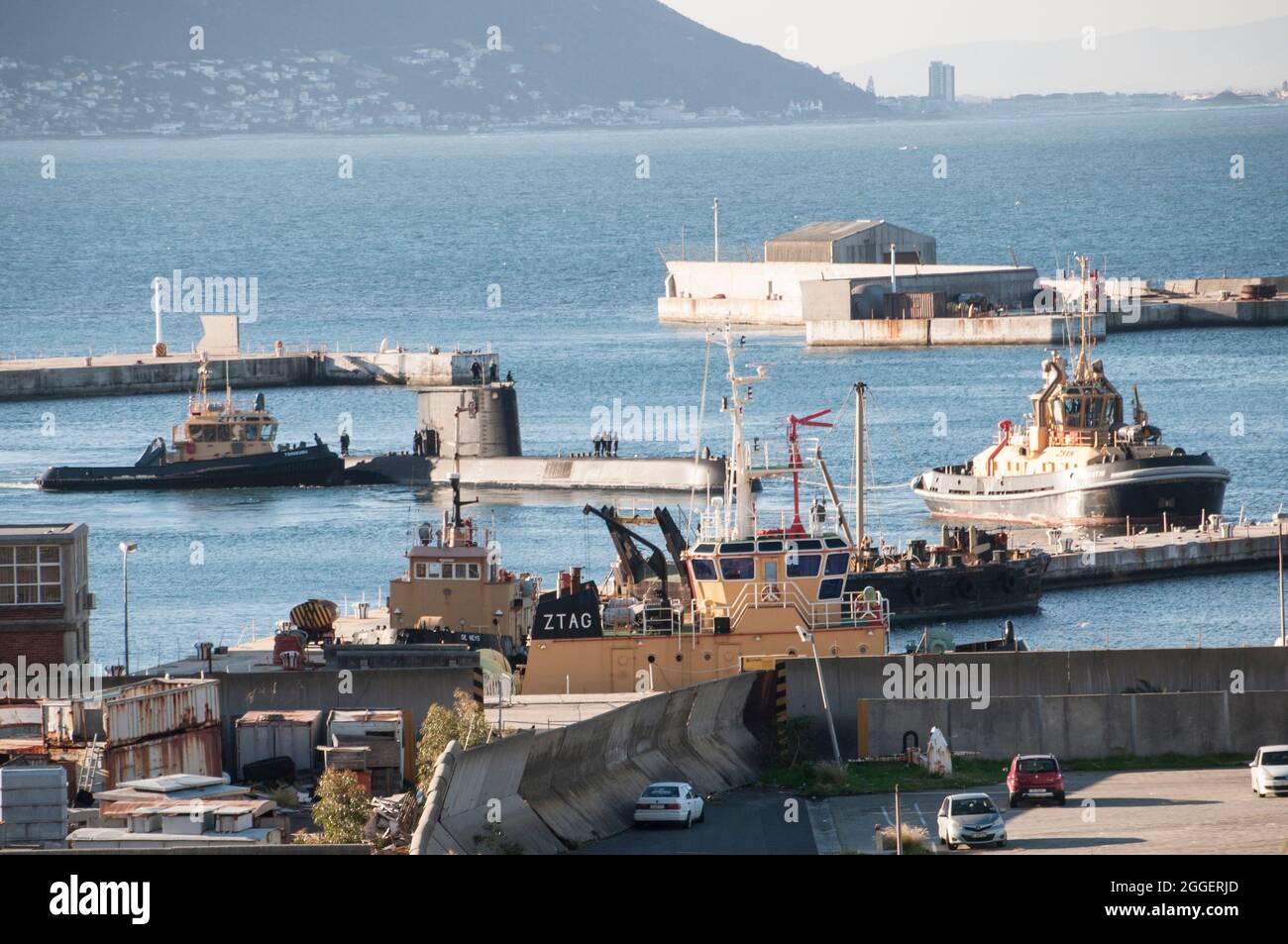 SA Navy Submarine docking with tugboats Stock Photo