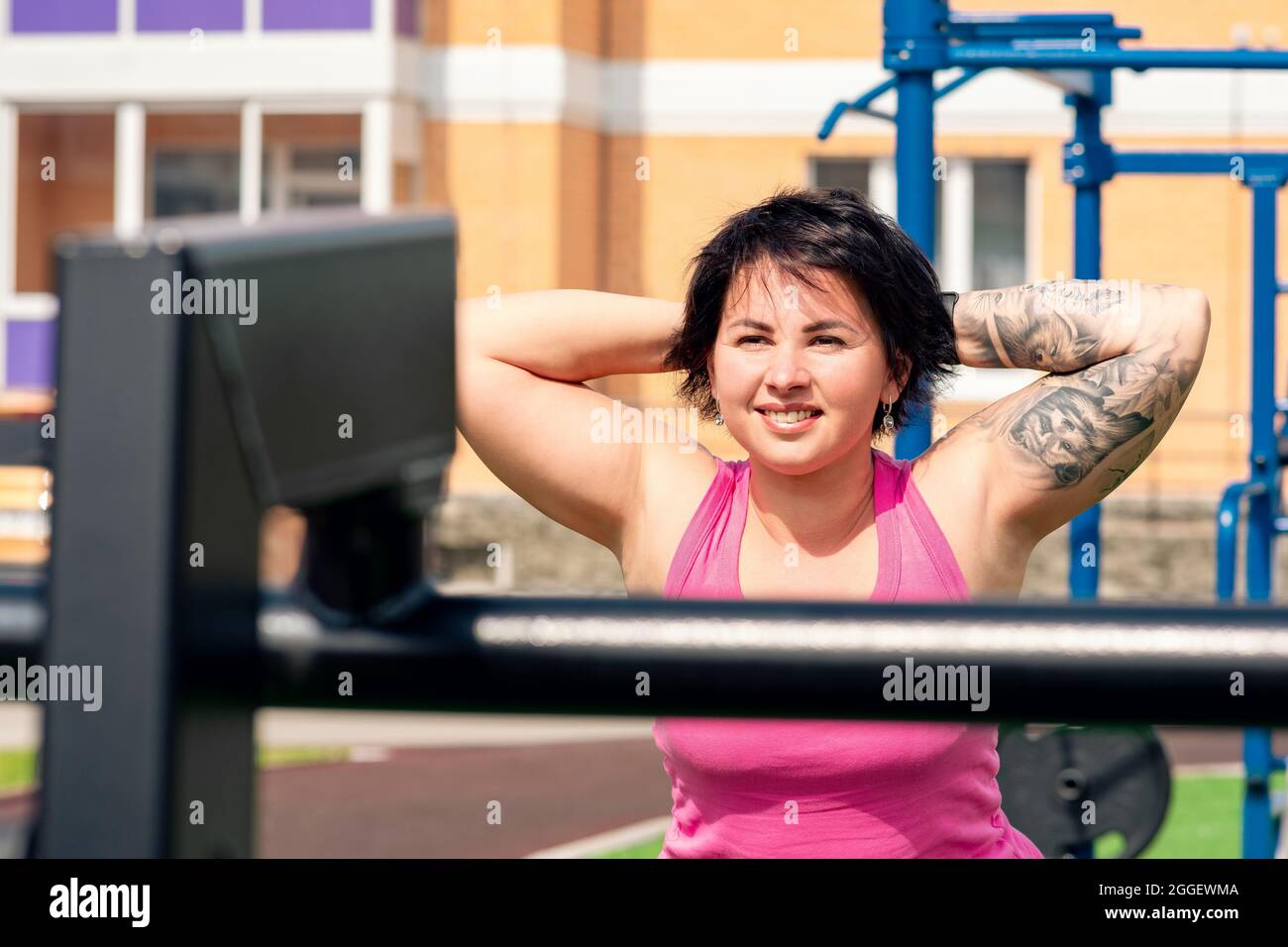 young woman performing back extension exercises in the city yard using