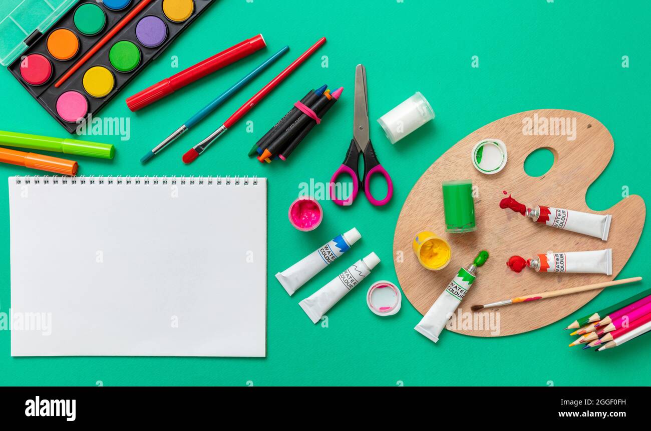 Creative kids, painting and drawing. Colorful paints and brushes on green  color background, empty blank paper, copy space, template. Education, Back  t Stock Photo - Alamy