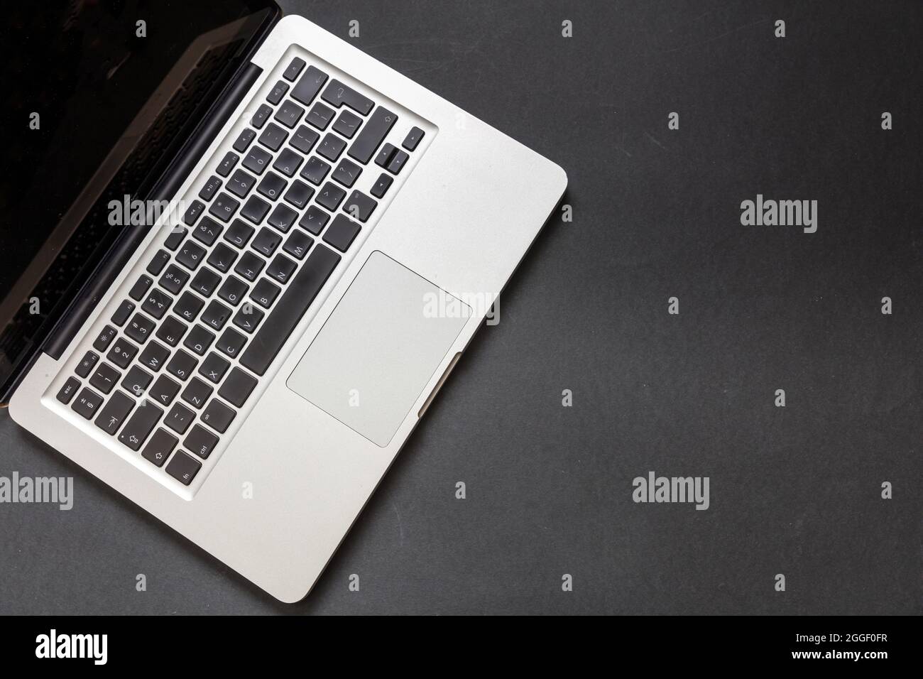 Laptop computer on black color background. Open laptop keyboard metal silver top view. Home office concept, copy space, template Stock Photo