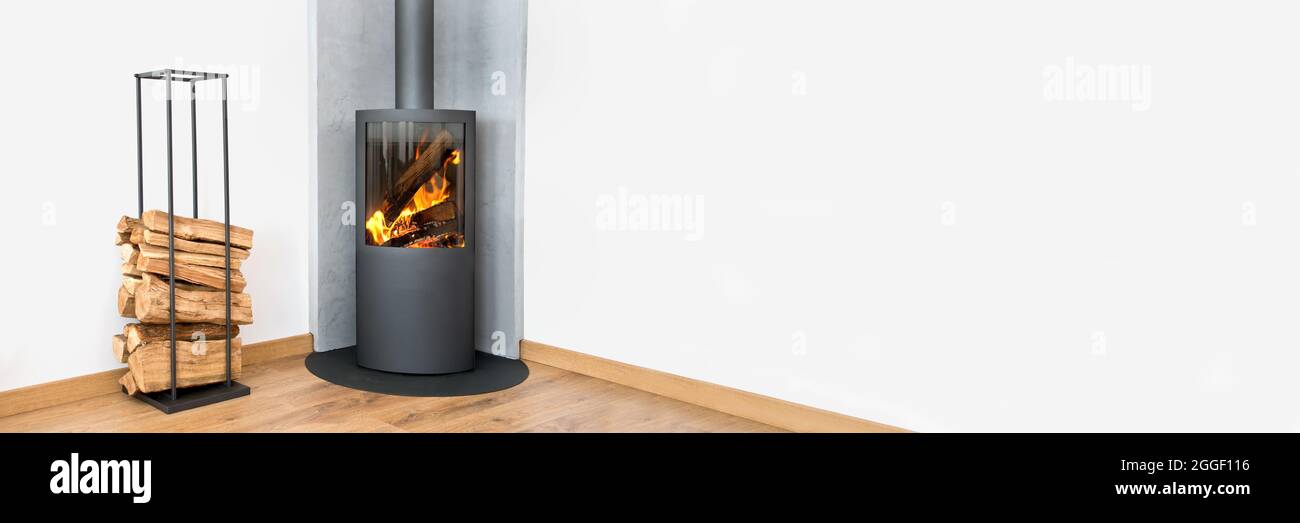 Modern wood burning stove. Panoramic contemporary home interior in winter Stock Photo