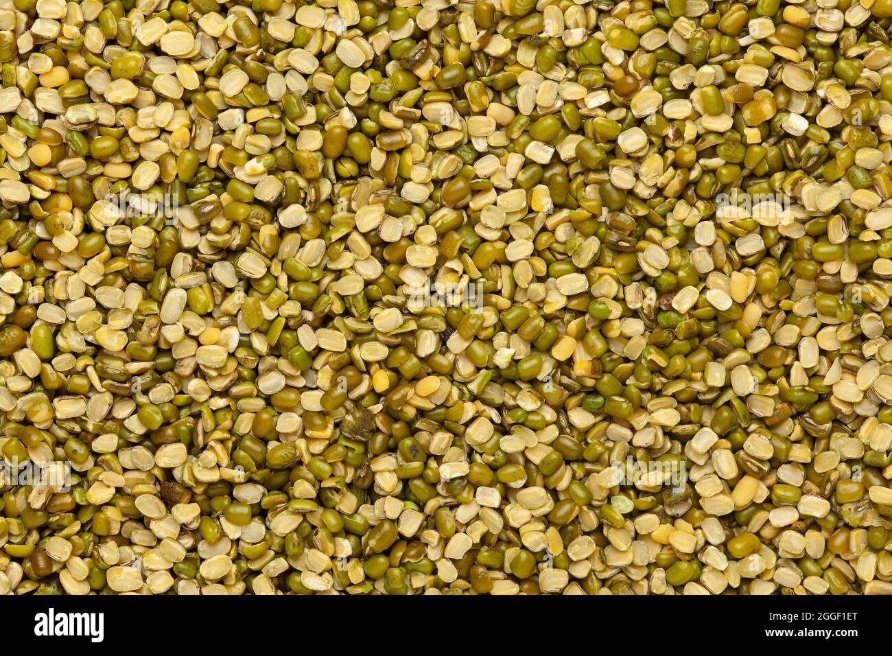 Close up of Organic green Gram (Vigna radiata) or spilt green moong dal unpolished spilled. Top view Stock Photo