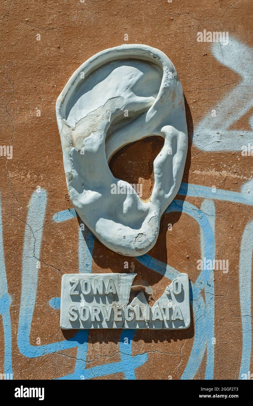 A plaster sculpture representing a big ear, street art by Urbansolid, affixed on a graffiti wall in the New Venice district, Livorno, Tuscany, Italy Stock Photo