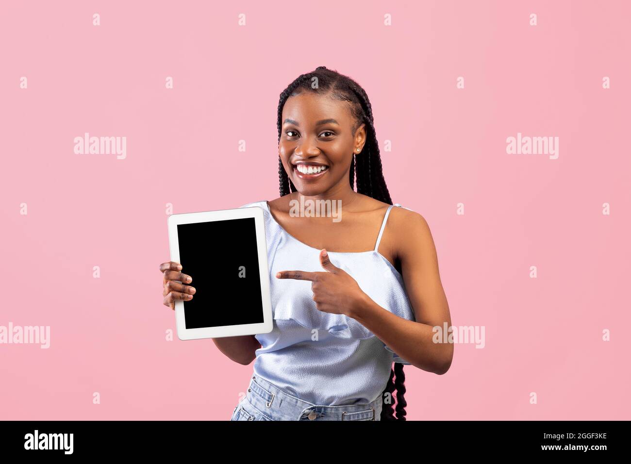 Positive young Afro woman pointing at tablet computer with empty screen ...