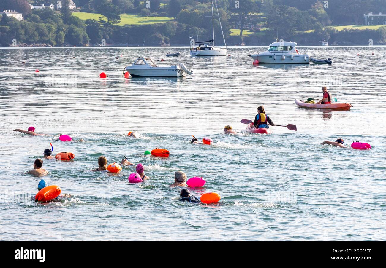 Group swimming in the sea with safety boat Union Hall, West Cork, Ireland Stock Photo