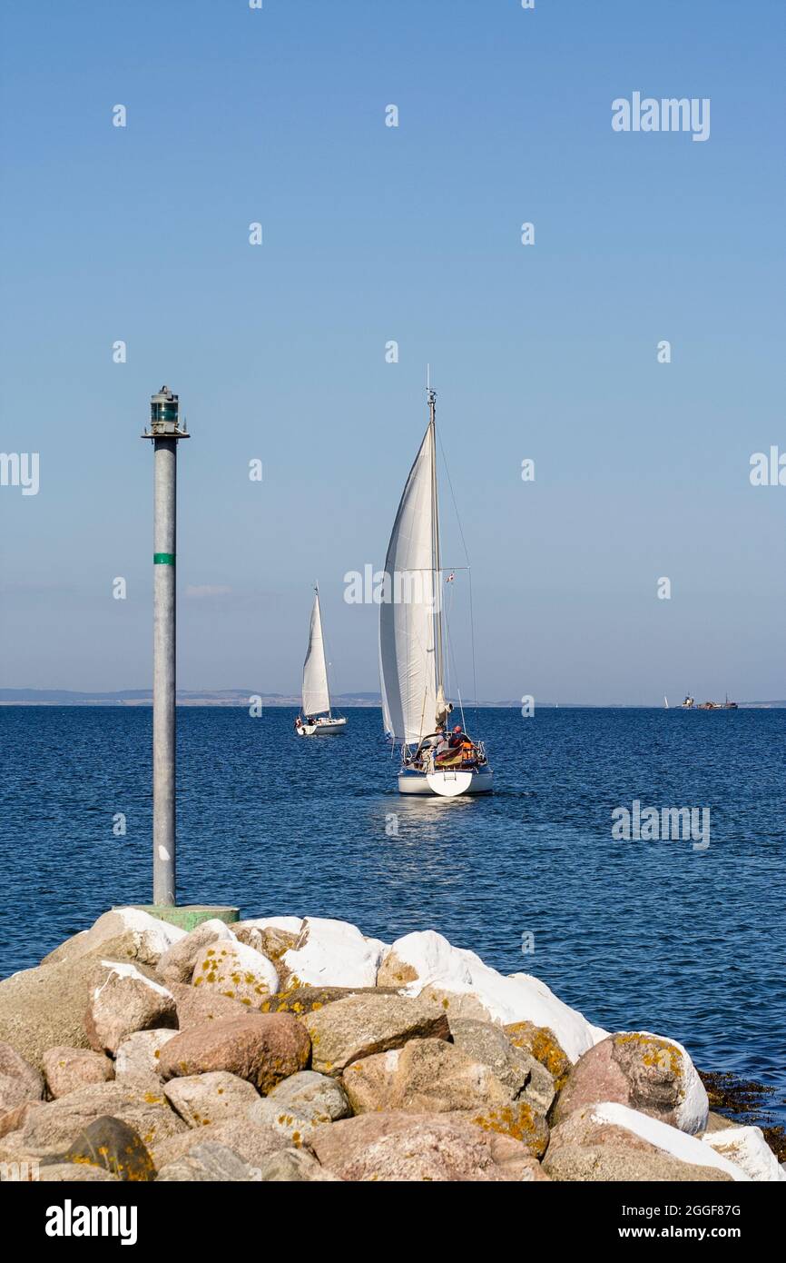 Two sailboats leaving the small port at Norsminde, Denmark Stock Photo
