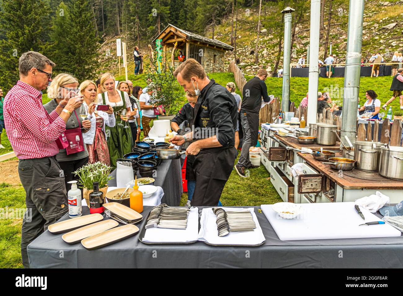 Unplugged Taste is the name of the gourmet event at the Gompm-Alm in South Tyrol, Italy. It takes place every year on the last Sunday in August. Famous chefs prepare their dishes on old wood stoves. Stock Photo