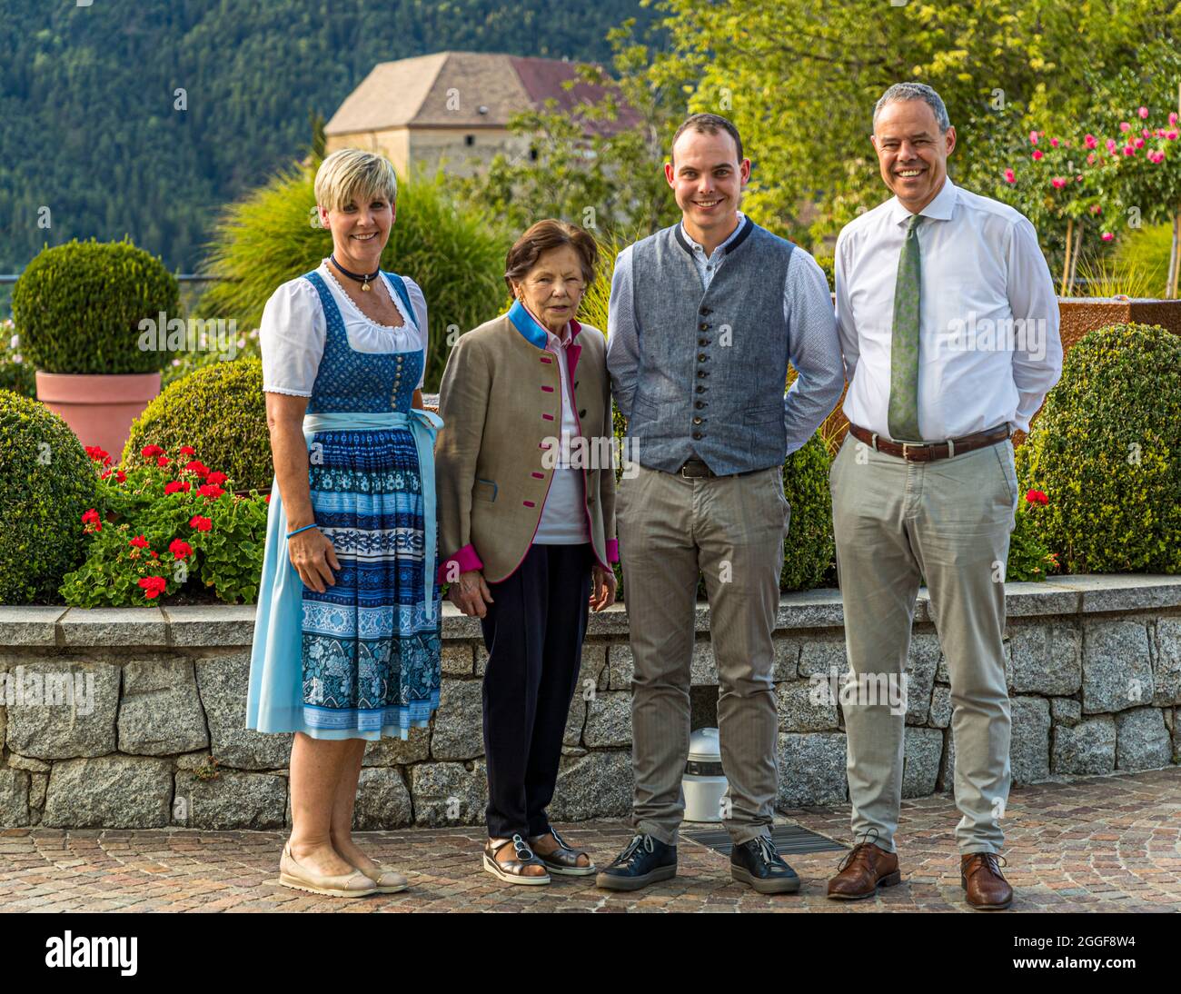 Three generations of the owner family Mair in front of the Hotel Hohenwart in Schenna, South Tyrol, Italy. Anna Mair, together with her late husband Franz Mair, built up the hotel in the 1960s. Today the management is in the hands of son Josef Mair with his wife. Grandson Franz Mair can be found in the service and he leads hikes for house guests Stock Photo