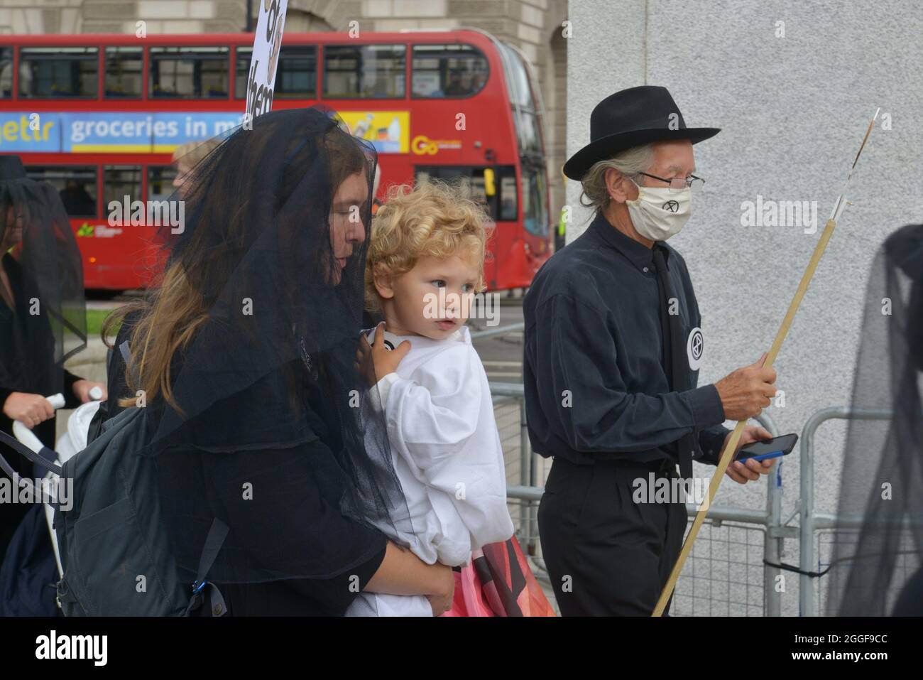 London, UK. 31st Aug, 2021. A veiled protester seen carrying a child while wearing funeral outfits during the demonstration.Extinction Rebellion protesters with baby strollers dressed themselves in funeral outfits at a rally in Parliament Square. (Photo by Thomas Krych/SOPA Images/Sipa USA) Credit: Sipa USA/Alamy Live News Stock Photo