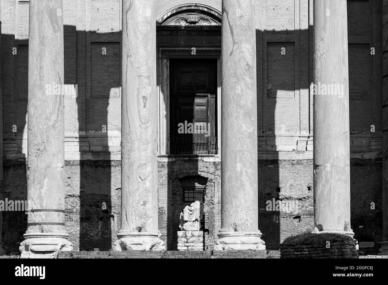 Black and white photo of ancient marble columns decorating entrance of ancient roman building Stock Photo
