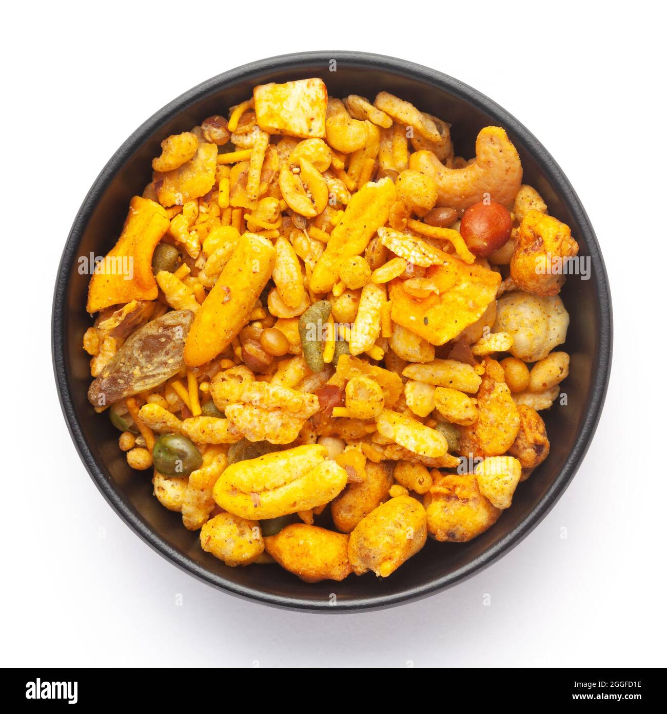 Close-Up of Indian spicy snacks (Namkeen) - (All in one) in a black Ceramic bowl, made with fried peanut, corn flakes, sweet pea, pulses, cashew nuts. Stock Photo