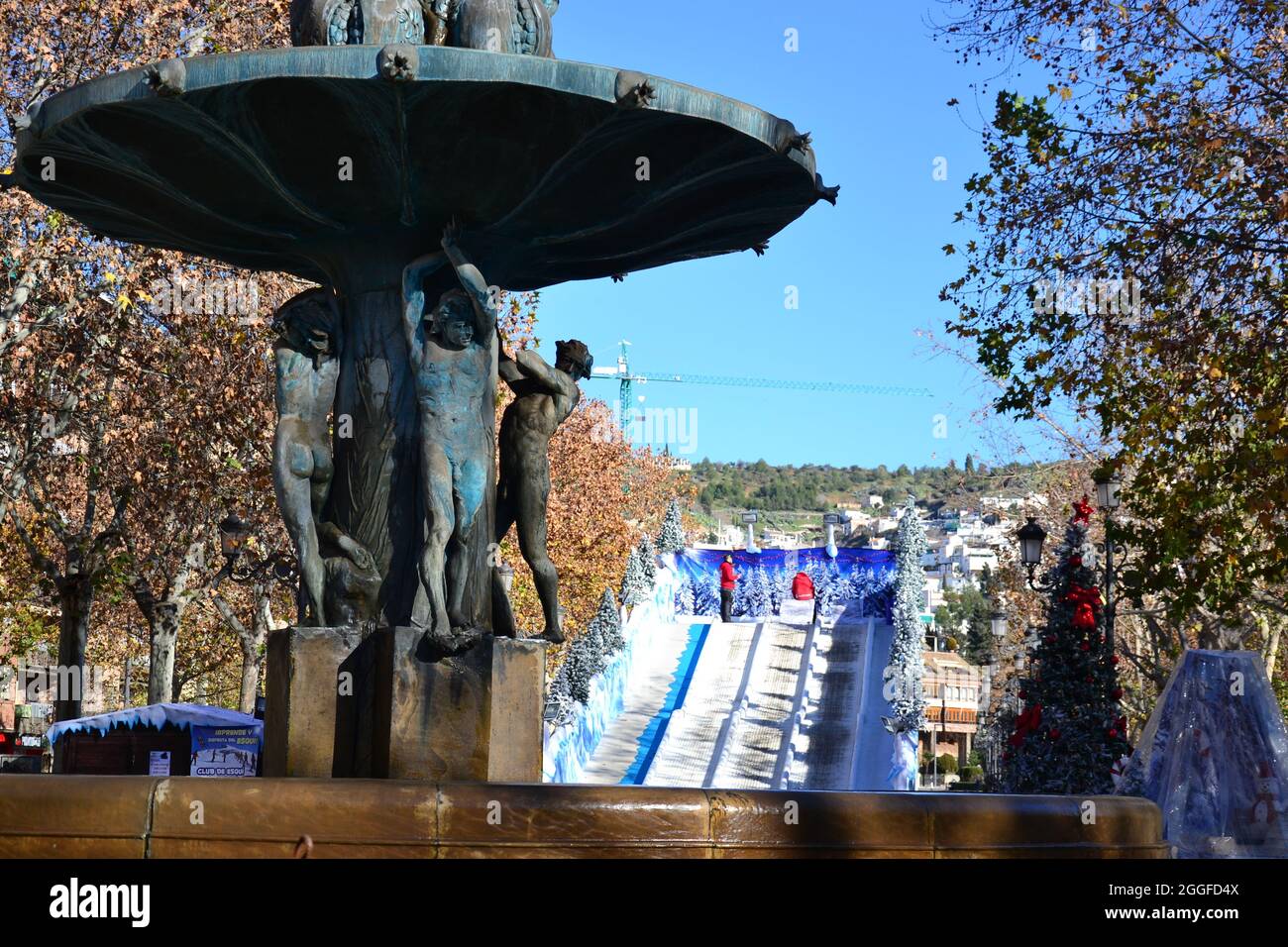 fountain of the pomegranates in Granada and a slide with Christmas decorations in the background Stock Photo