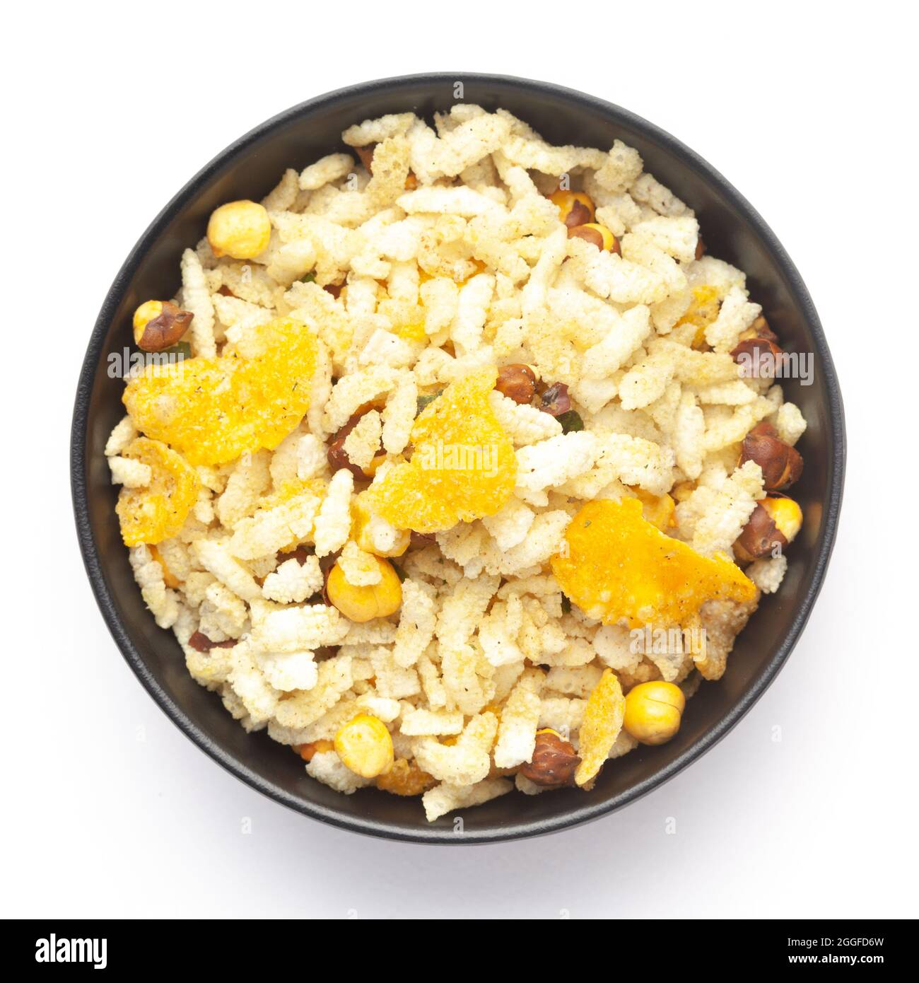 Close-Up of Crunchy Diet Mixture in a black Ceramic bowl made with Puffed Rice, Corn Flakes, and Curry leaves. Indian spicy snacks (Namkeen) Top  View Stock Photo