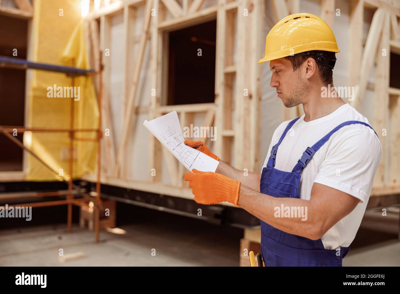 Male construction worker studying architectural building plan Stock Photo