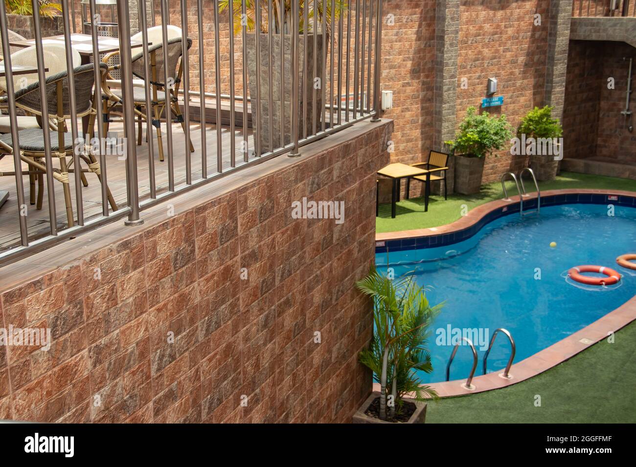 Small swimming pool in private luxury residence villa, with tables and chairs around, decorative plants Stock Photo