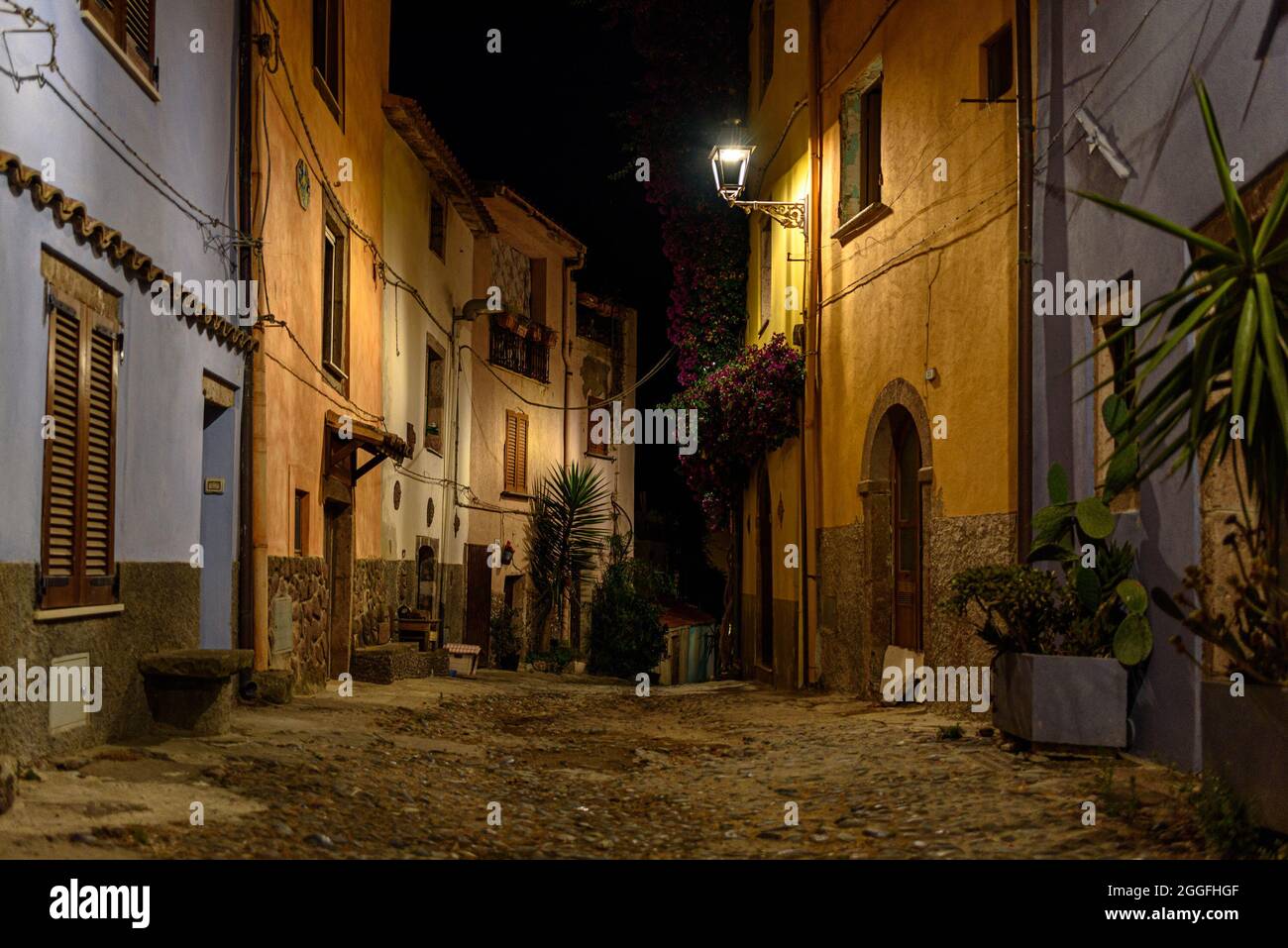 The narrow cobblestone streets of old town Bosa at night Stock Photo