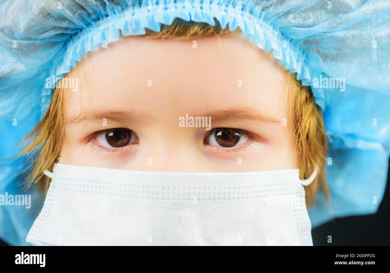 Child in mask for protection against Covid-19 coronavirus pandemic. Illness prevention. Small boy in medical cap and mask. Closeup. Stock Photo