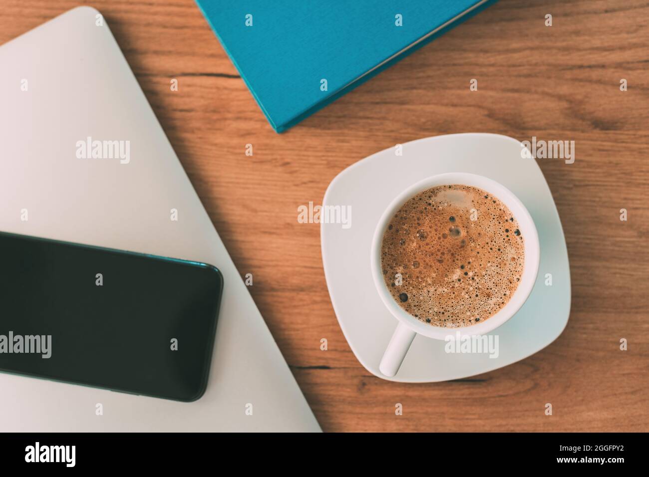 Morning coffee before starting the freelance job, coffee cup on home office desk, top view Stock Photo