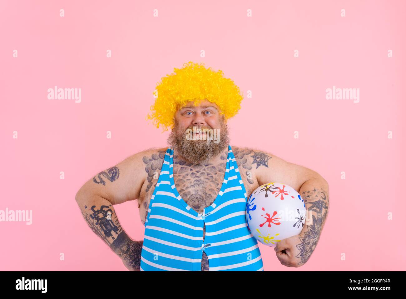 Fat happy man with beard and wig play with the ball Stock Photo