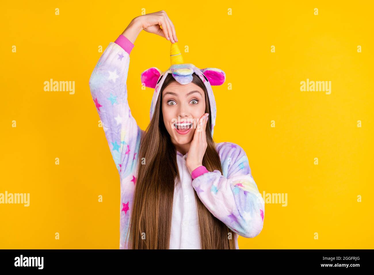 Portrait of attractive cheerful comic girl having fun wear animal look touching horn isolated over bright yellow color background Stock Photo