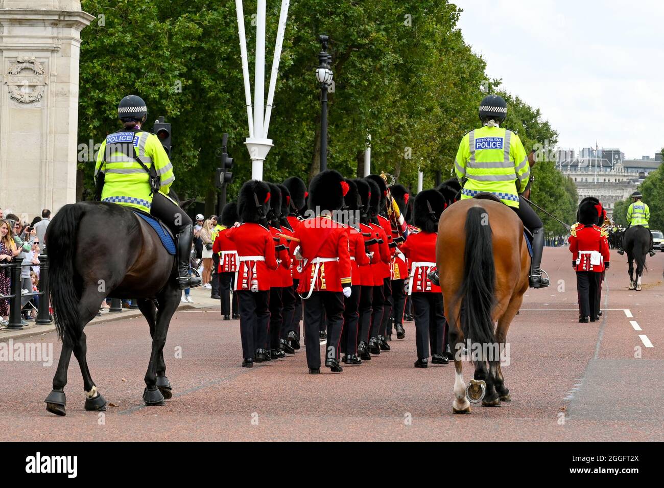 London, England - August 2021: Two police officers on horses escorting Guards in full uniform down The Mall Stock Photo