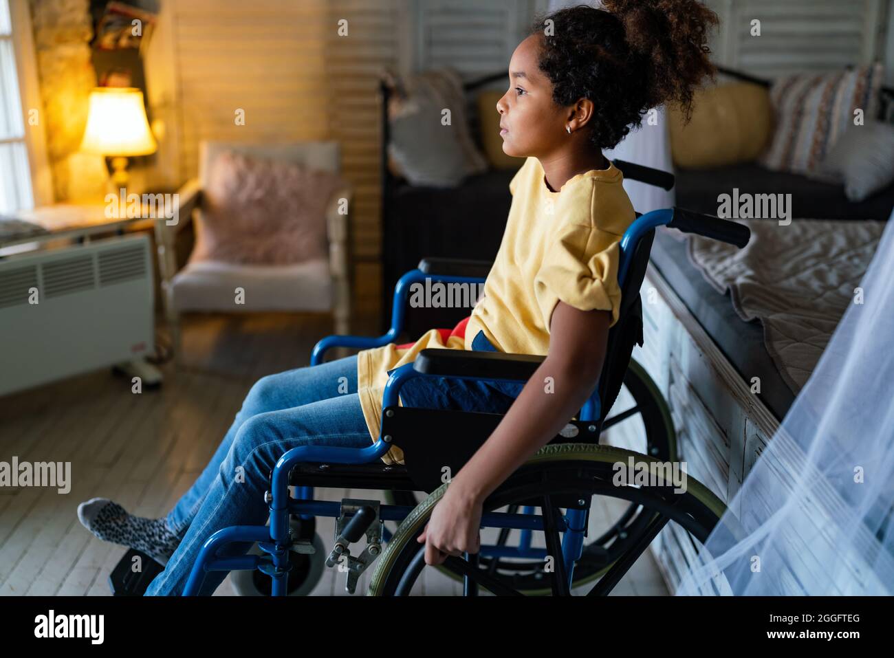 Portrait of disabled black girl with wheelchair at home Stock Photo