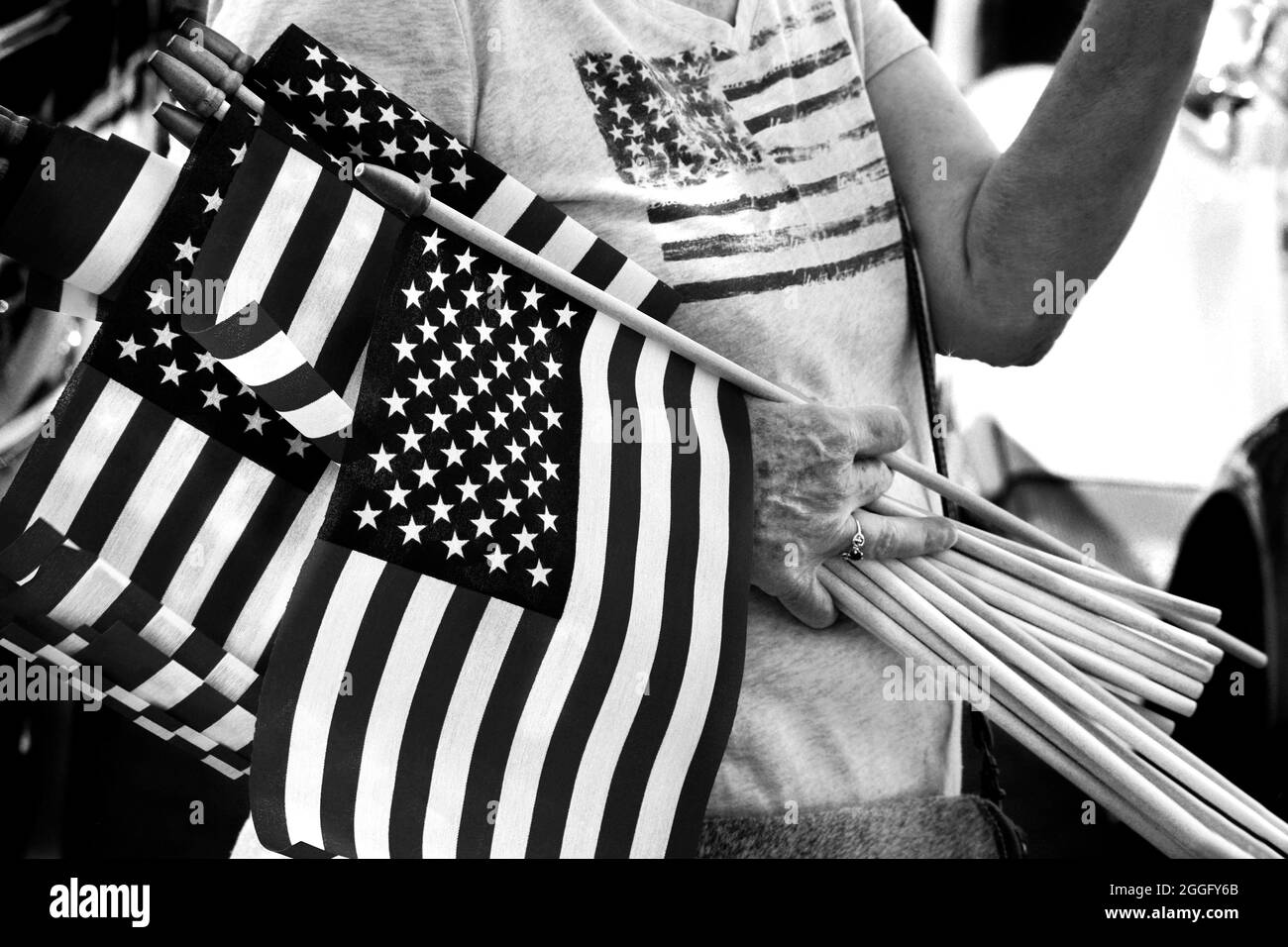 A woman distributes small American flags at a Fourth of July vintage car show in Santa Fe, New Mexico. Stock Photo