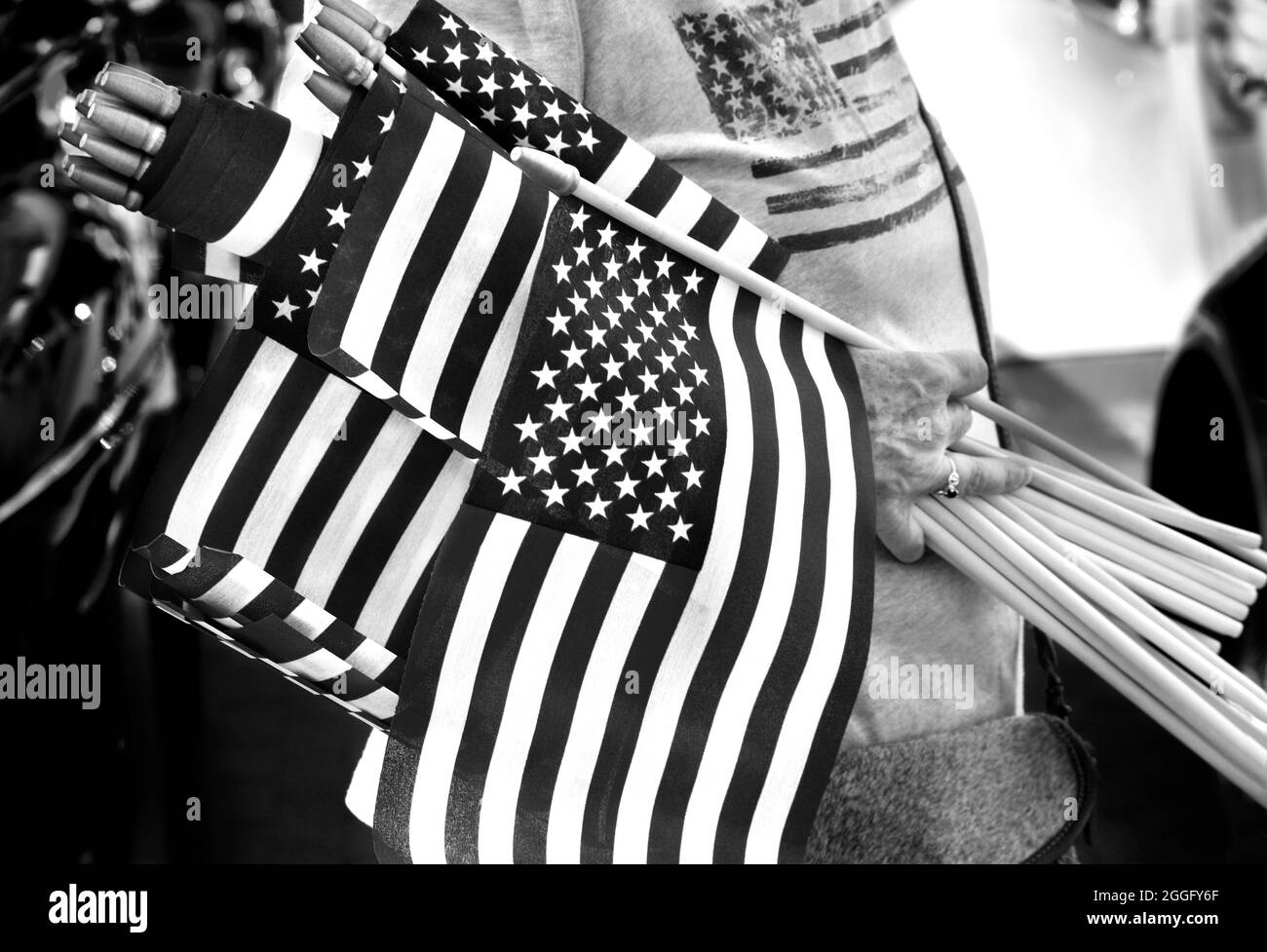 A woman distributes small American flags at a Fourth of July vintage car show in Santa Fe, New Mexico. Stock Photo