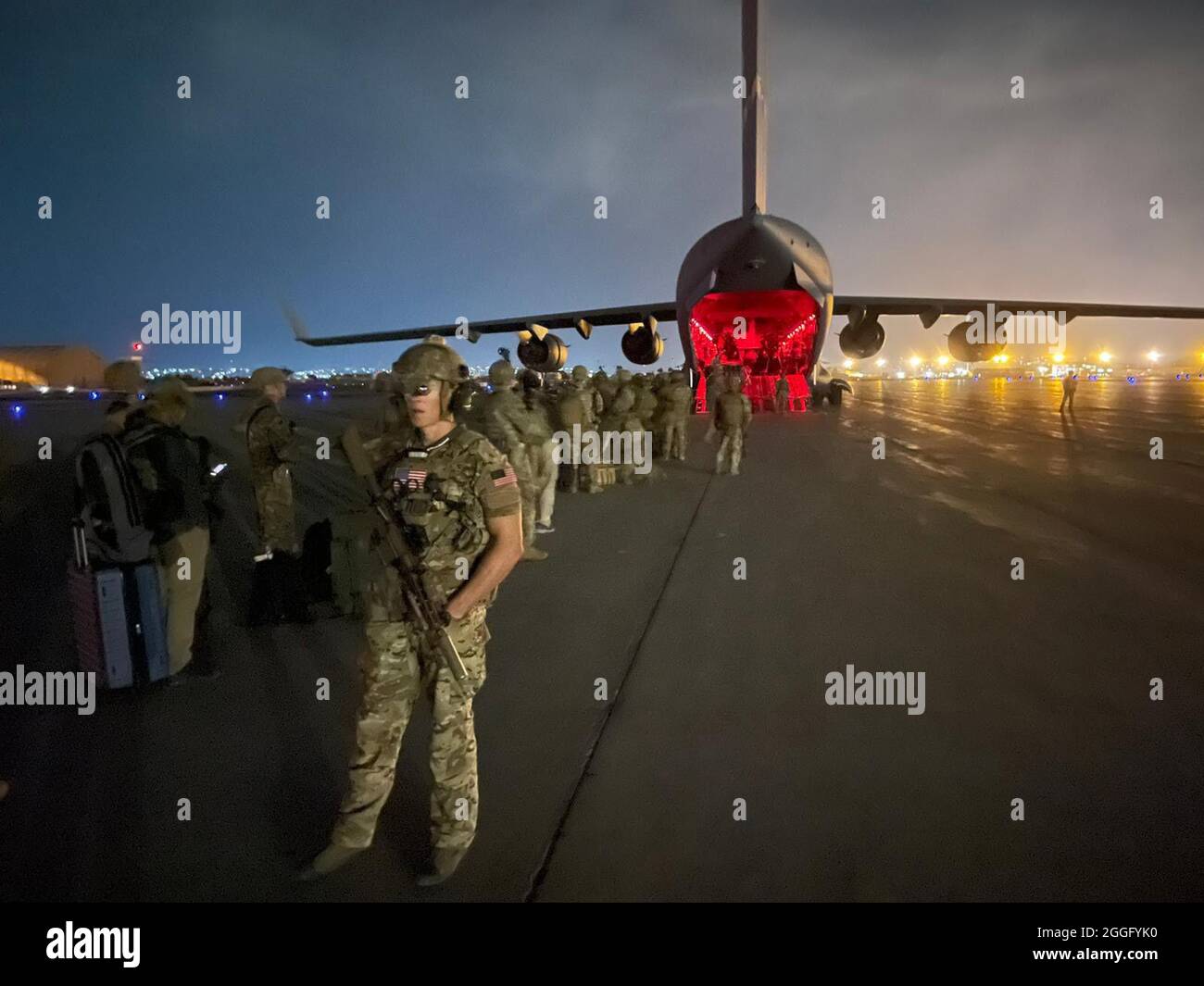 Paratroopers assigned to the 82nd Airborne Division prepare to board a U.S. Air Force C-17 on August 30th, 2021 at the Hamid Karzai International Airport. Maj. Gen. Donahue was the last American Soldier to leave Afghanistan ending the U.S. mission in Kabul. (U.S. Army photo by Master Sgt. Alexander Burnett, 82nd Airborne Public Affairs). Stock Photo